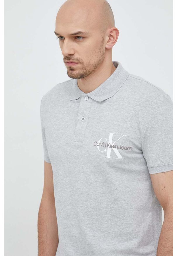 Calvin Klein Jeans polo męski kolor szary z nadrukiem. Typ kołnierza: polo. Kolor: szary. Materiał: dzianina. Długość: krótkie. Wzór: nadruk