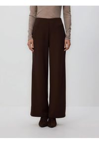 Reserved - Spodnie z szerokimi nogawkami - ciemnobrązowy. Kolor: brązowy. Materiał: tkanina. Wzór: gładki #1