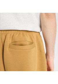 Spodnie męskie New Balance MB61M77EABG – pomarańczowe. Kolor: pomarańczowy. Materiał: poliester, bawełna, materiał, dresówka. Wzór: aplikacja, napisy #6