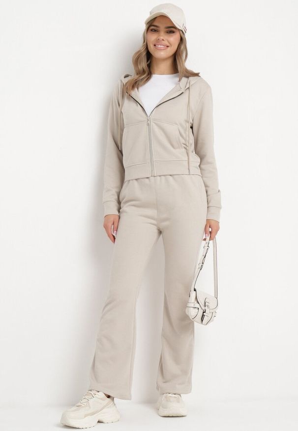 Born2be - Beżowy Bawełniany Komplet Dresowy Bluza z Kapturem i Spodnie Dzwony Nanre. Kolor: beżowy. Materiał: dresówka, bawełna. Wzór: aplikacja