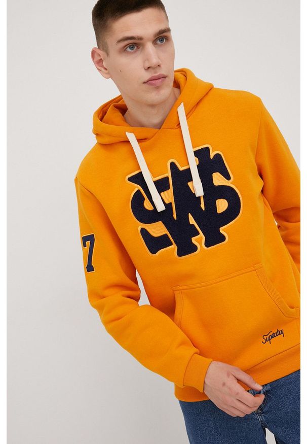 Superdry bluza męska kolor pomarańczowy z kapturem z aplikacją. Typ kołnierza: kaptur. Kolor: pomarańczowy. Materiał: dzianina. Wzór: aplikacja