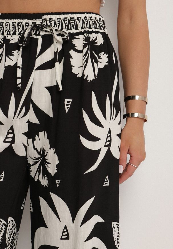 Born2be - Czarne Spodnie z Tropikalnym Wzorem i Szerokimi Nogawkami Emivelli. Okazja: na co dzień. Kolor: czarny. Styl: elegancki, casual