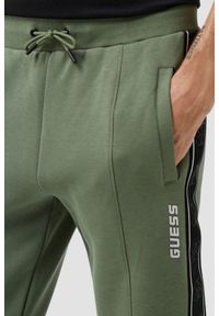 Guess - GUESS Zielone męskie spodnie dresowe z lampasami Mickey, Rozmiar XL. Kolor: zielony. Materiał: dresówka #3