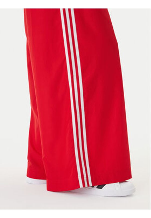 Adidas - adidas Spodnie dresowe Firebird Adilenium KD6299 Czerwony Regular Fit. Kolor: czerwony. Materiał: syntetyk