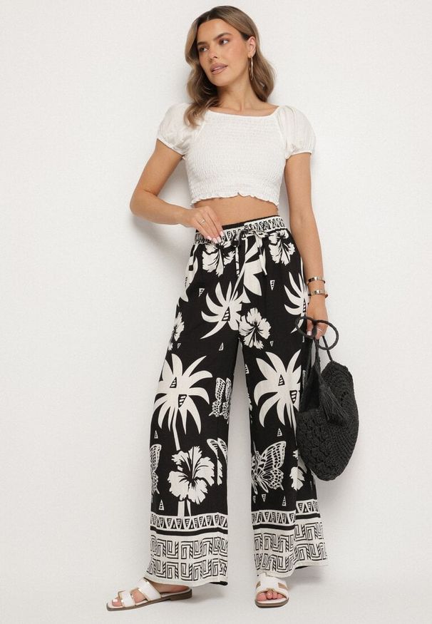 Born2be - Czarne Spodnie z Tropikalnym Wzorem i Szerokimi Nogawkami Emivelli. Okazja: na co dzień. Kolor: czarny. Styl: elegancki, casual