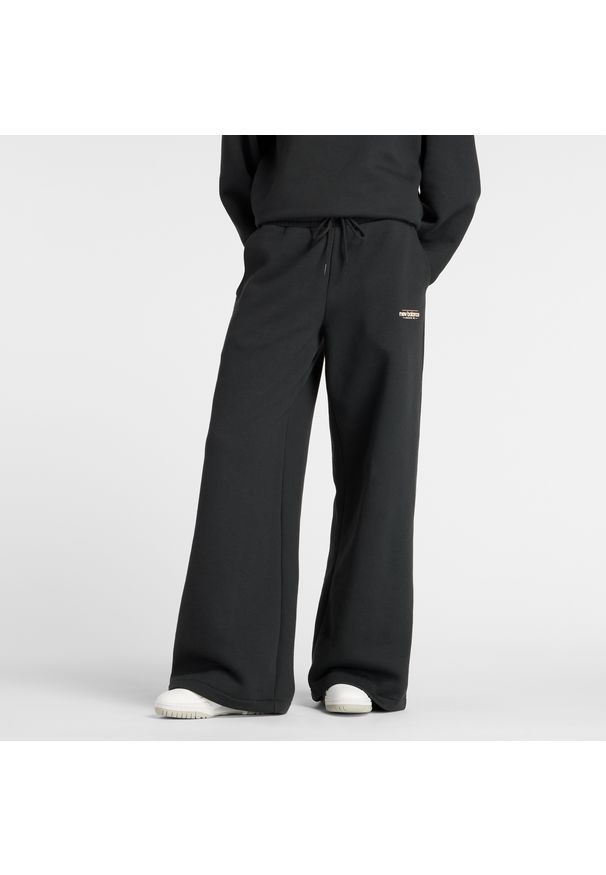 Spodnie damskie New Balance WP53903BK – czarne. Stan: podwyższony. Kolor: czarny. Materiał: poliester, bawełna. Wzór: aplikacja, napisy