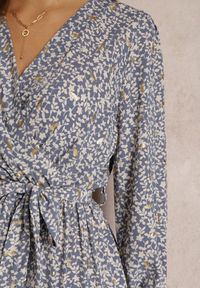 Renee - Niebieska Sukienka Elala. Typ kołnierza: dekolt w kształcie V. Kolor: niebieski. Materiał: materiał. Długość rękawa: długi rękaw. Wzór: kwiaty. Typ sukienki: kopertowe. Długość: midi
