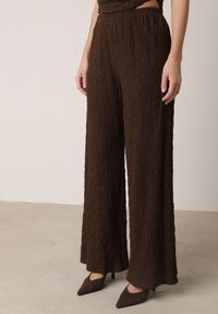 Born2be - Brązowy Gładki Komplet Szerokie Spodnie i Marszczona Bluzka ze Stójką Merithie. Kolor: brązowy. Materiał: materiał. Wzór: gładki #3