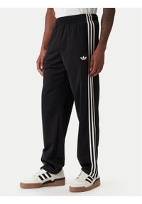 Adidas - adidas Spodnie dresowe Firebird KD8315 Czarny Loose Fit. Kolor: czarny. Materiał: syntetyk #1