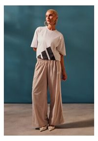 Adidas - adidas Spodnie dresowe Essentials 3-Stripes JC8168 Beżowy Loose Fit. Kolor: beżowy. Materiał: syntetyk #4