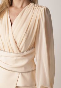 Born2be - Beżowa Bluzka Kopertowa VICES z Dekoltem V Bufiastymi Rękawkami i Zaakcentowanymi Ramionami Tine. Okazja: na co dzień, na komunię. Typ kołnierza: dekolt w kształcie V. Kolor: beżowy. Materiał: jeans. Długość rękawa: krótki rękaw. Styl: casual, elegancki #5