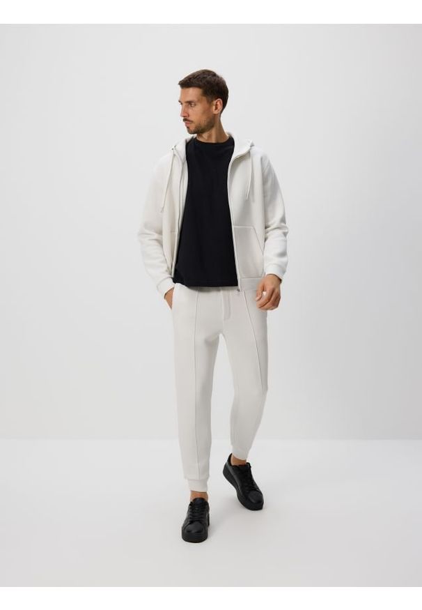 Reserved - Spodnie dresowe slim fit - złamana biel. Materiał: dresówka