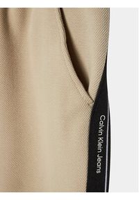 Calvin Klein Jeans Spodnie dresowe Interlock IB0IB01931 Beżowy Relaxed Fit. Kolor: beżowy. Materiał: bawełna
