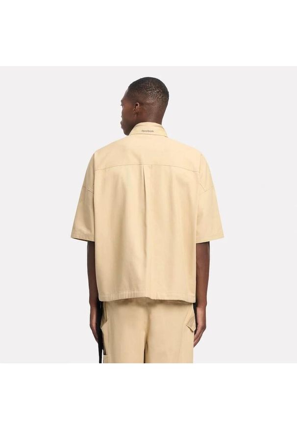 Reebok - Kurtka REEBOK S S SHIRT Jasnobrązowy. Kolor: brązowy, wielokolorowy, beżowy. Materiał: tkanina