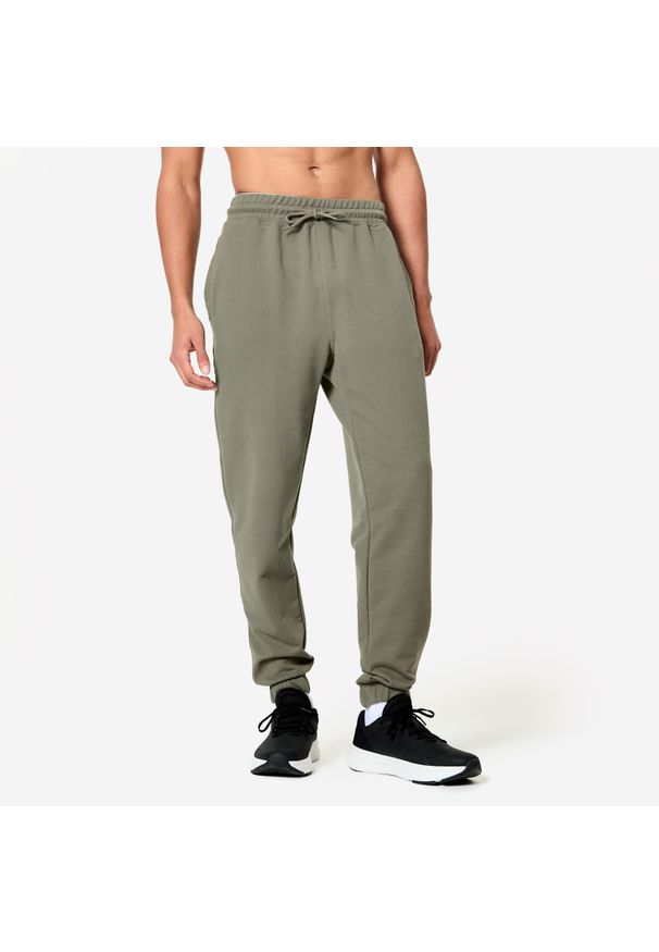 NYAMBA - Spodnie fitness męskie Domyos Gym & Pilates slim. Kolor: brązowy, zielony, wielokolorowy. Materiał: dresówka, materiał, dzianina. Wzór: ze splotem. Sport: fitness, joga i pilates