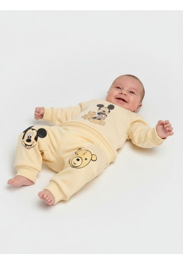 Sinsay - Spodnie z polarem w środku Mickey Mouse - kremowy. Kolor: kremowy. Materiał: polar. Wzór: motyw z bajki