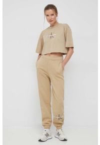 Calvin Klein Jeans spodnie dresowe damskie kolor beżowy z nadrukiem. Kolor: beżowy. Materiał: dresówka. Wzór: nadruk #1
