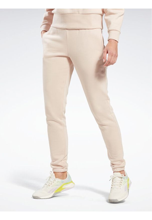 Reebok Spodnie dresowe Fleece IC3502 Beżowy Slim Fit. Kolor: beżowy. Materiał: bawełna, syntetyk