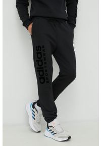 Adidas - adidas spodnie dresowe kolor czarny z aplikacją. Kolor: czarny. Materiał: dresówka. Wzór: aplikacja #1