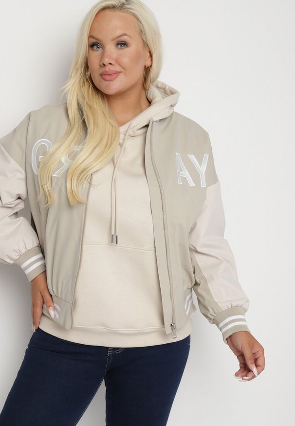 Born2be - Beżowa Kurtka Bomberka o Kroju Oversize z Paskami i Napisami Nevilora. Okazja: na co dzień. Kolor: beżowy. Materiał: jeans. Wzór: napisy. Styl: casual