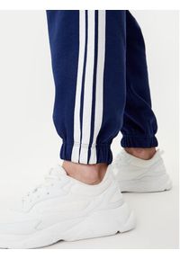 Adidas - adidas Spodnie dresowe Essentials 3-Stripes Fleece JX7696 Niebieski Loose Fit. Kolor: niebieski. Materiał: syntetyk, bawełna #5