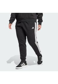 Adidas - Spodnie Essentials 3-Stripes Fleece Slim (Plus Size). Kolekcja: plus size. Kolor: czarny, biały, wielokolorowy. Materiał: polar. Sport: fitness #1