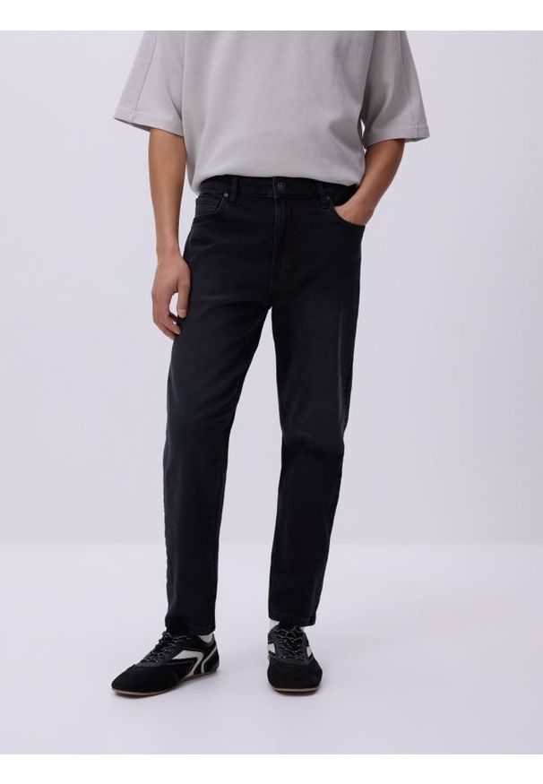 Reserved - Jeansy carrot slim z efektem sprania - czarny. Kolor: czarny
