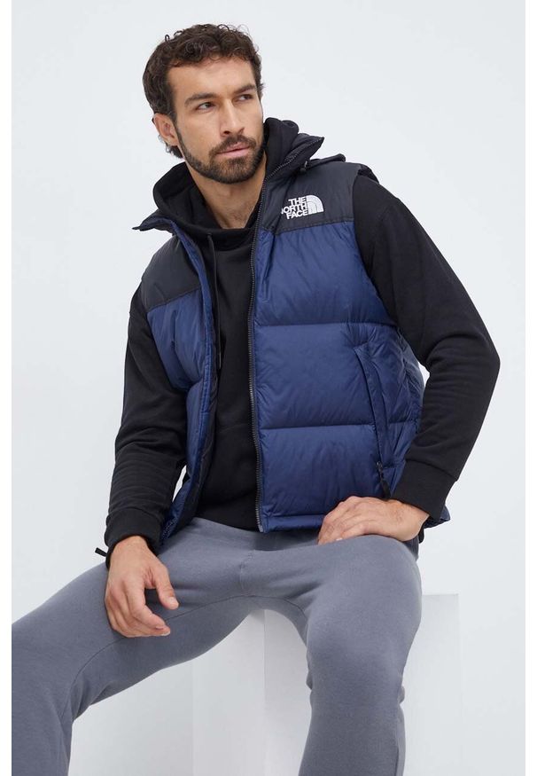 The North Face bezrękawnik puchowy męski kolor granatowy zimowy. Typ kołnierza: kaptur. Kolor: niebieski. Materiał: puch. Długość rękawa: bez rękawów. Sezon: zima