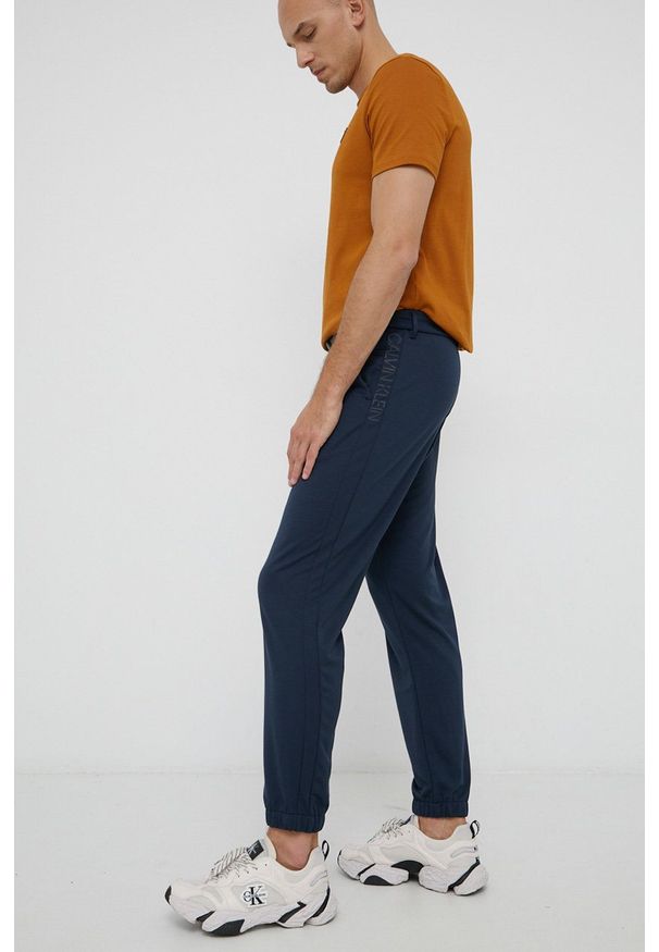 Calvin Klein Spodnie męskie kolor granatowy z nadrukiem. Kolor: niebieski. Wzór: nadruk