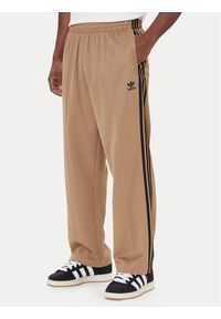 Adidas - adidas Spodnie dresowe adicolor Firebird JY1419 Beżowy Baggy Fit. Kolor: beżowy. Materiał: bawełna