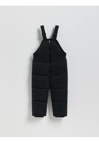 Reserved - Gumowane spodnie na szelkach - czarny. Kolor: czarny. Materiał: materiał #1