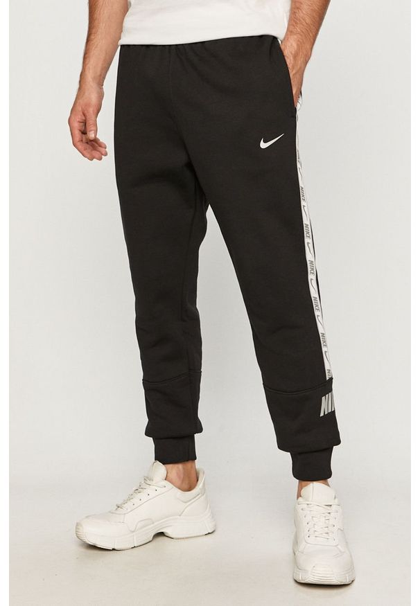Nike Sportswear - Spodnie. Kolor: czarny. Materiał: bawełna, poliester, dzianina. Wzór: aplikacja