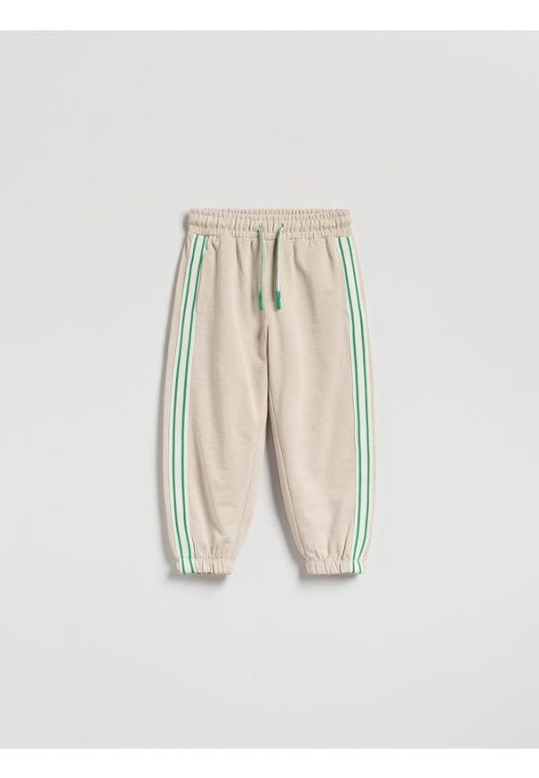 Reserved - Dresowe spodnie z lampasem - beżowy. Kolor: beżowy. Materiał: dresówka