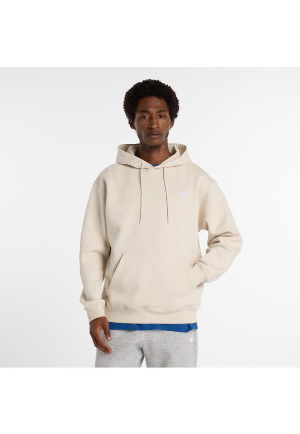 Bluza męska New Balance MT41511TWF – beżowa. Typ kołnierza: kaptur. Kolor: beżowy. Materiał: dresówka, poliester, bawełna. Wzór: aplikacja
