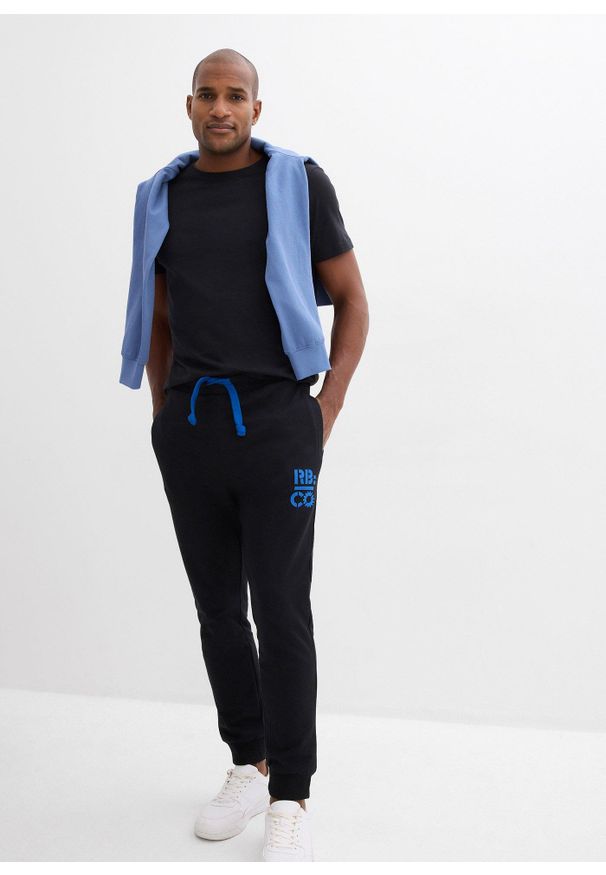 bonprix - Spodnie sportowe z kontrastowymi elementami. Kolor: czarny. Materiał: poliester, dresówka. Wzór: nadruk. Styl: sportowy