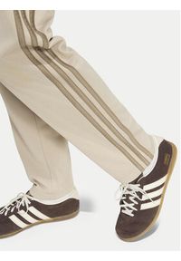 Adidas - adidas Spodnie dresowe Firebird HZ6652 Beżowy jasny Regular Fit. Kolor: beżowy. Materiał: syntetyk #6
