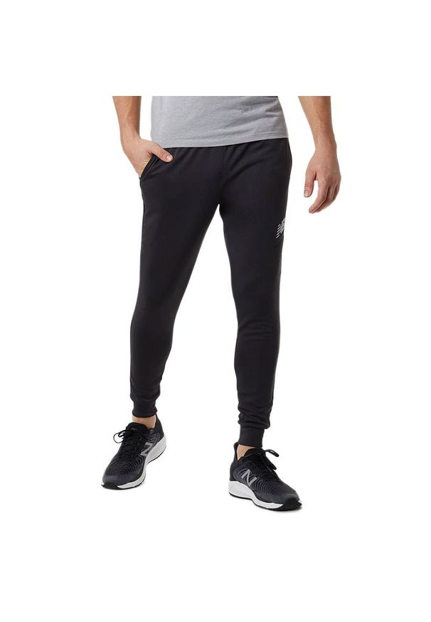 Spodnie New Balance MP23091PHM - czarne. Kolor: czarny. Materiał: dresówka, poliester. Sport: turystyka piesza, fitness, wspinaczka