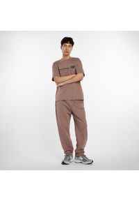 Spodnie męskie New Balance MP53508EAS – brązowe. Kolor: brązowy. Materiał: bawełna, dresówka, materiał, poliester. Wzór: aplikacja, napisy #4