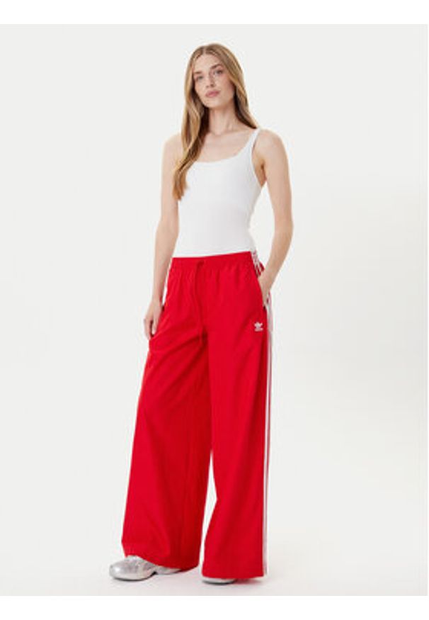 Adidas - adidas Spodnie dresowe adicolor Firebird JD3388 Czerwony Loose Fit. Kolor: czerwony. Materiał: syntetyk