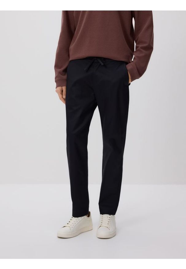 Reserved - Spodnie carrot fit - granatowy. Kolor: niebieski. Materiał: tkanina