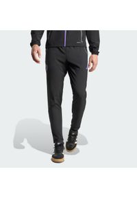 Adidas - Spodnie Manchester United Tiro 25 Competition Vis Tech Travel. Kolor: wielokolorowy, fioletowy, czarny. Sport: piłka nożna #1