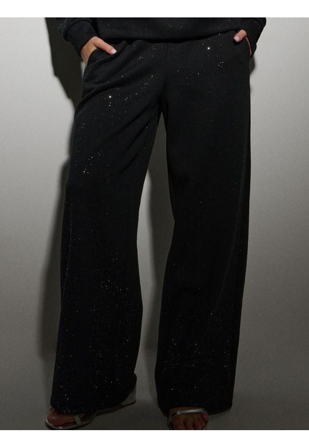 Sinsay - Dresowe spodnie z szeroką nogawką i brokatem - czarny. Kolor: czarny. Materiał: dresówka