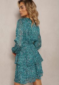 Renee - Niebieska Sukienka Oreithinca. Typ kołnierza: dekolt kopertowy, typu klepsydra. Kolor: niebieski. Materiał: tkanina, materiał. Długość rękawa: długi rękaw. Wzór: nadruk. Typ sukienki: kopertowe
