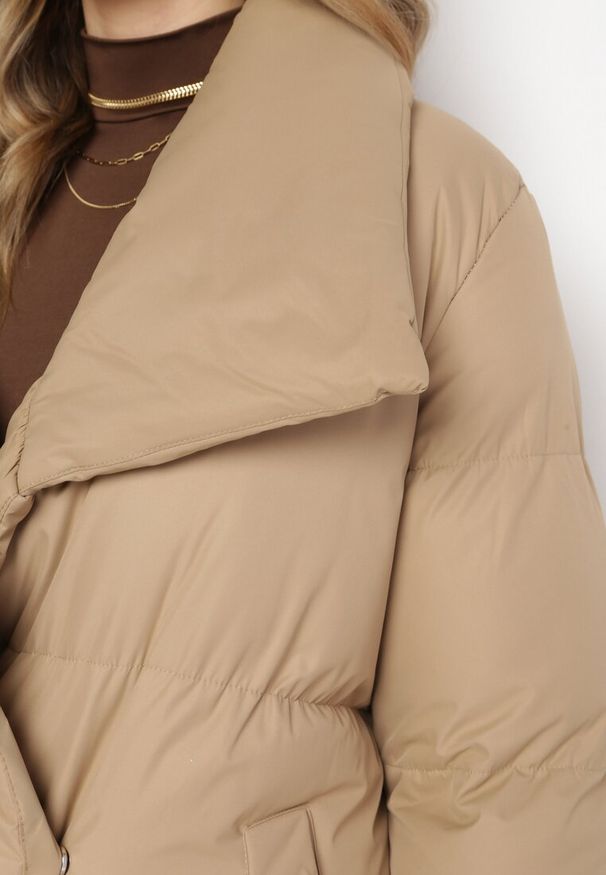 Born2be - Ciemnobeżowa Kurtka Płaszcz Zapinana na Napy Ukryte pod Plisą z Kieszeniami i Paskiem Ritallas. Typ kołnierza: kołnierzyk stójkowy. Kolor: beżowy. Materiał: materiał. Długość: długie. Sezon: zima