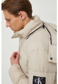 Calvin Klein Jeans kurtka męska kolor beżowy zimowa. Kolor: beżowy. Materiał: włókno, materiał. Wzór: nadruk. Sezon: zima #7