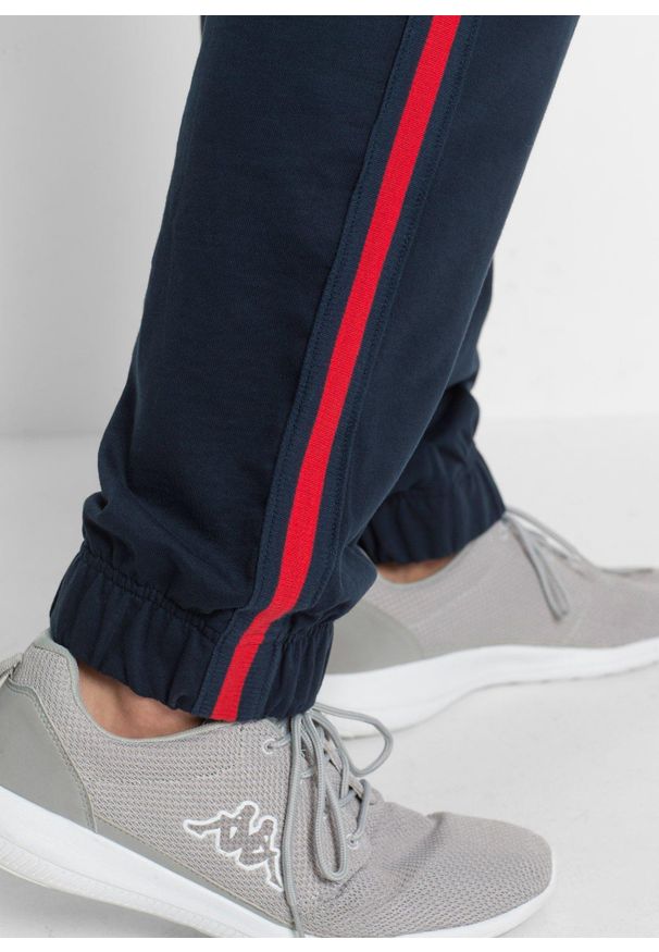bonprix - Spodnie sportowe z kontrastowymi elementami. Kolor: niebieski. Materiał: dresówka. Styl: sportowy