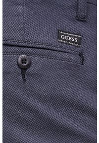 Guess Spodnie męskie kolor granatowy dopasowane. Kolor: niebieski. Materiał: tkanina, materiał #2