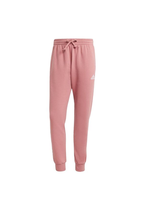 Adidas - Essentials Fleece Regular Tapered Pants. Kolor: czerwony, wielokolorowy, różowy, czarny. Materiał: materiał