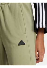 Adidas - adidas Spodnie dresowe Signature Graphic JI6524 Zielony Loose Fit. Kolor: zielony. Materiał: bawełna