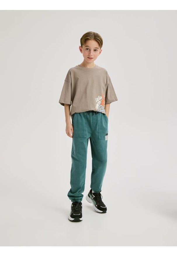 Reserved - Joggery z efektem sprania - morski. Kolor: morski. Materiał: dzianina, bawełna